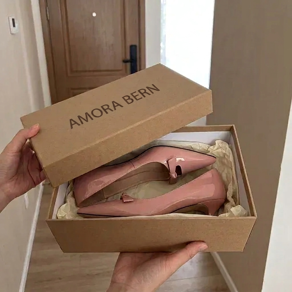 Geöffnete AMORA BERN-Schachtel mit einem Paar rosa Lackpumps